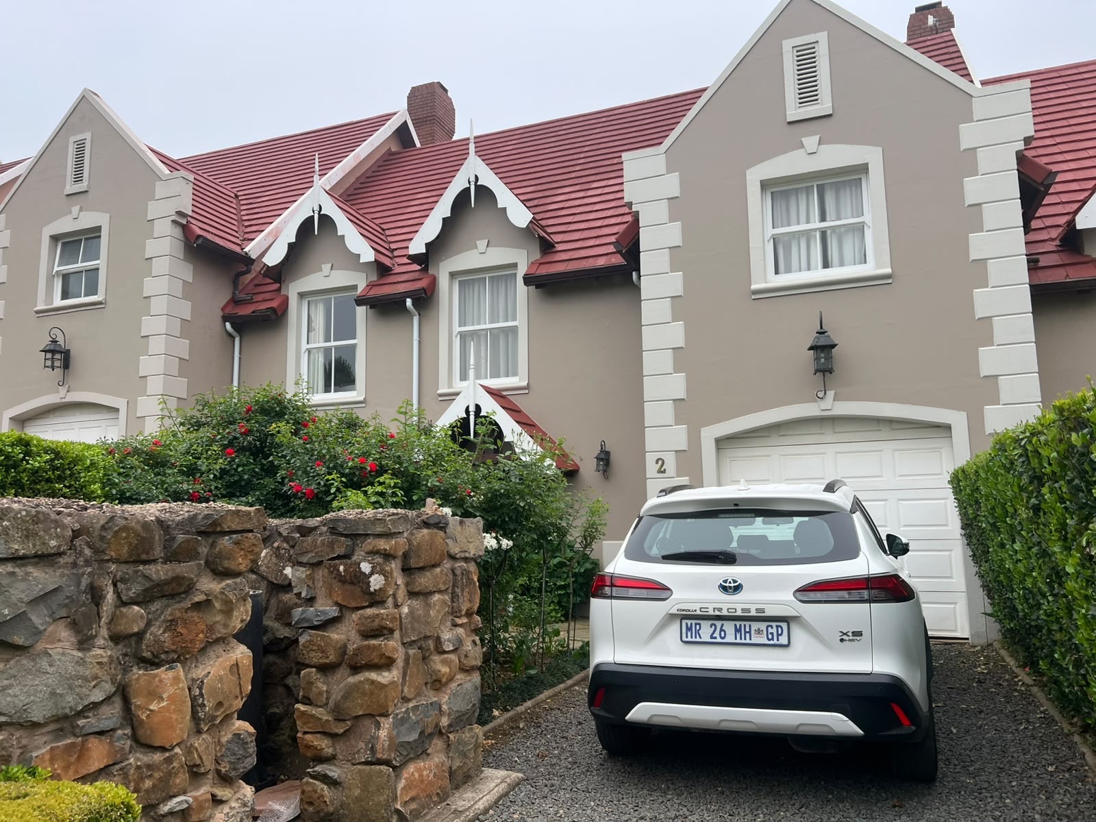 The house with its red roof and stone garden wall